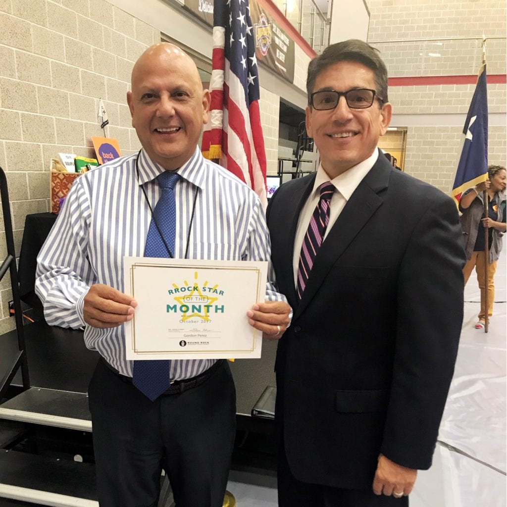 Gordon Perez holding RRock Star of the Month certificate with Superintendent Flores