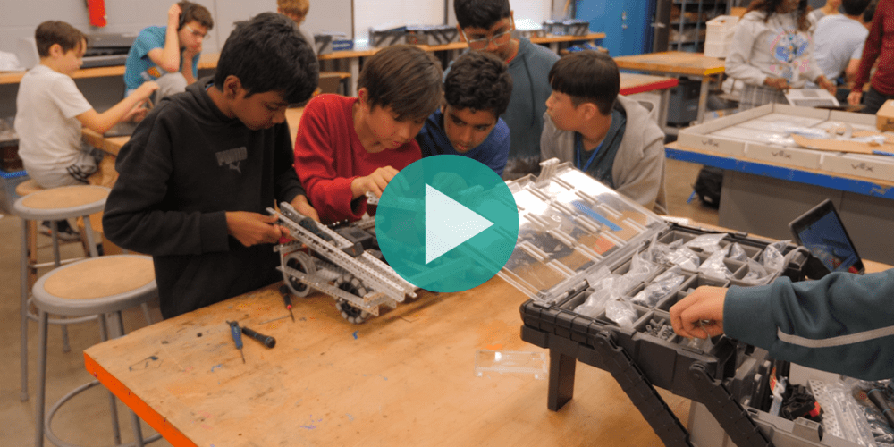 Picture of middle school students working together to construct a robot.